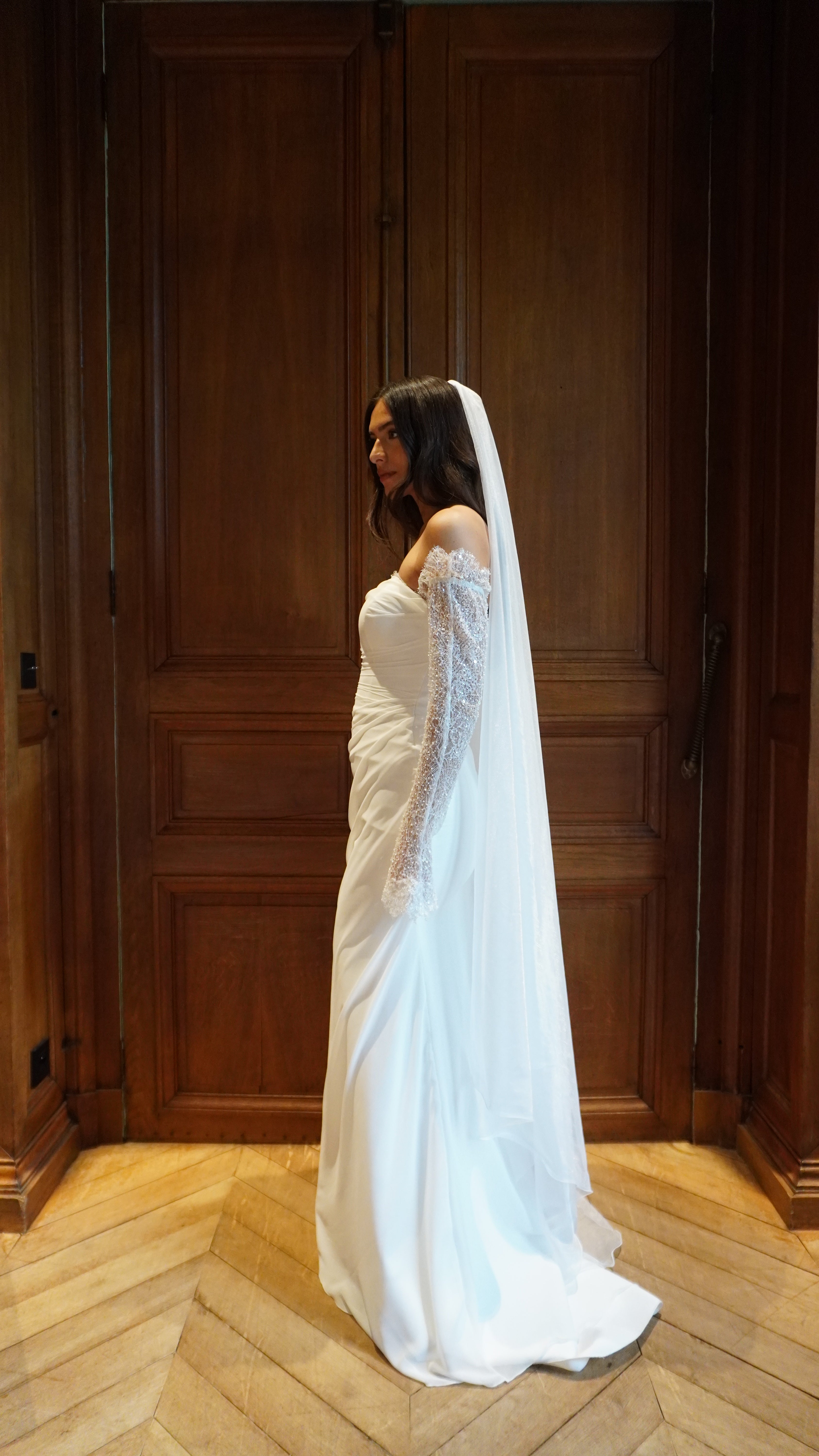 Strapless draped mermaid wedding gown with lace detail captured in motion, highlighting the fluidity of the fabric and the elegance of the drape.