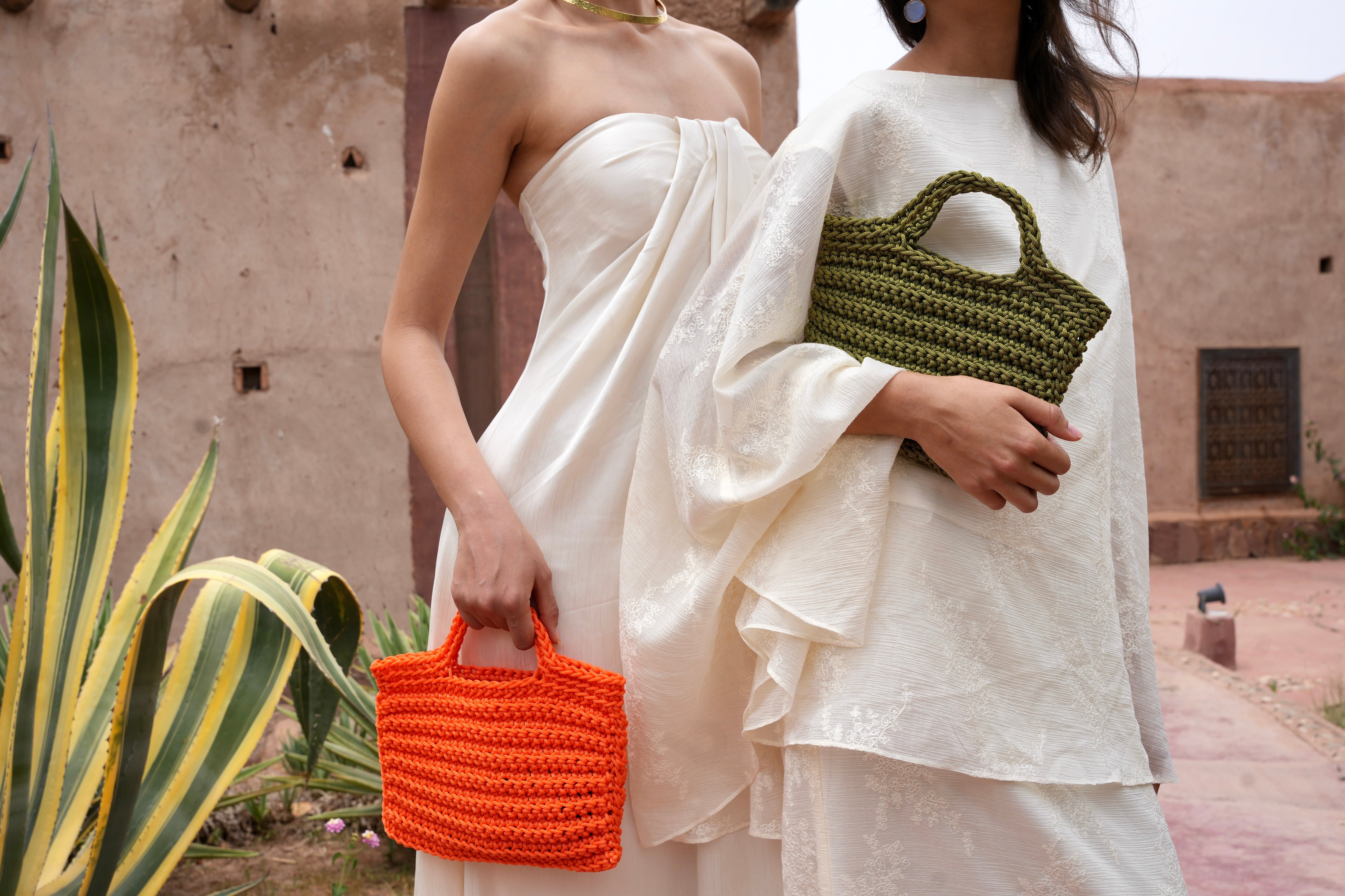 Two models each carrying a square crochet bag handmade in Marrakech, comparative view